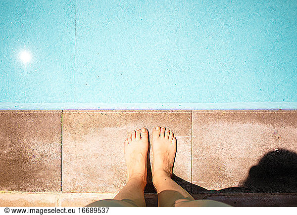female legs and feet in blue swimming pool