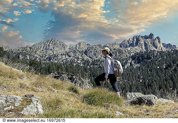 Female middle aged Spanish tourist walking by Spanish Pyrenees mountain during sunny day
