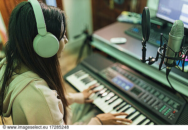 Female musician playing piano in studio