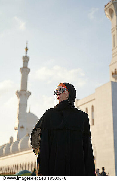Female muslim traveler is sightseeing in Arab country at sunset.