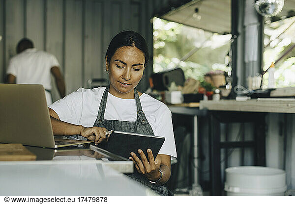 Female owner working on digital tablet in food truck