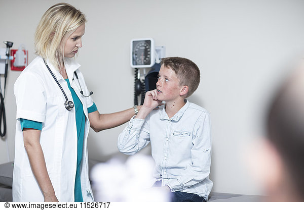 Female pedeatrician examining boy with an otoscope