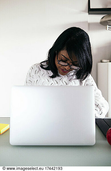 Female professional wearing eyeglasses while sitting at desk