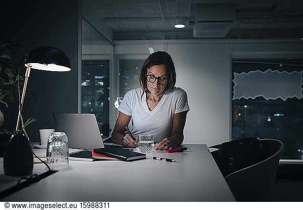 Female professional working late while sitting at desk in office