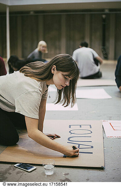 Female protestor preparing signboard in building