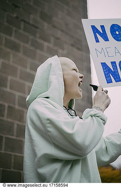 Female protestor screaming with signboard during social movement