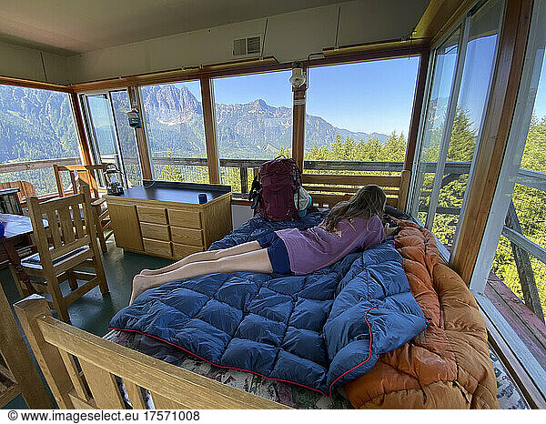 Female relaxing inside a fire lookout tower in the Cascade Mountains