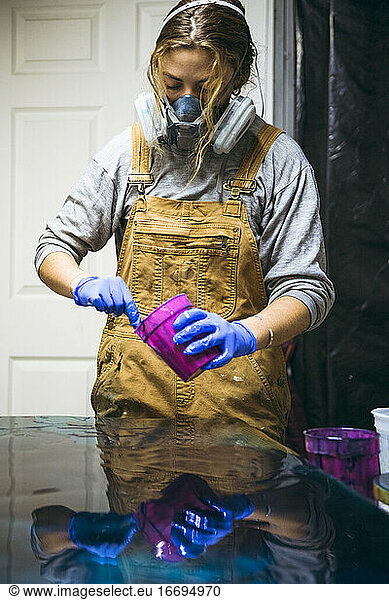 Female resin artist mixing resin tint for new artwork