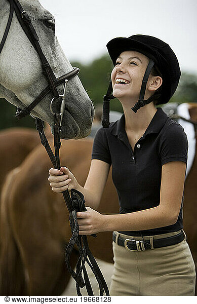 female rider smiles at white horse