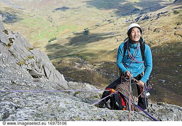 female rock climber at belay anchor point on Tryfan in North Wales