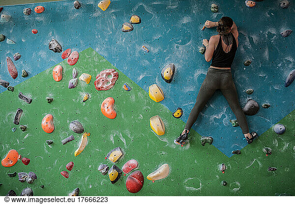 Female rock climber training on climbing wall