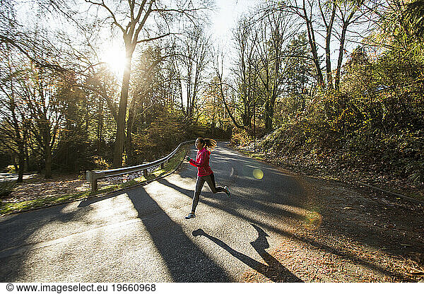 Female runner jogging on road near Lake Washington  Seattle  Washington State  USA