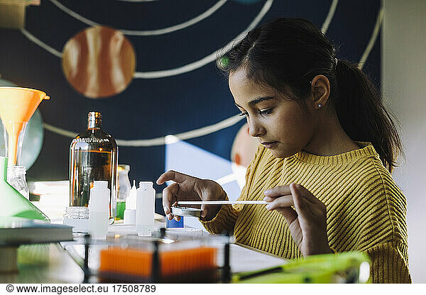 Female scientist doing scientific experiment at table