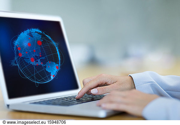 Female scientist looking at global pandemic outbreaks on laptop