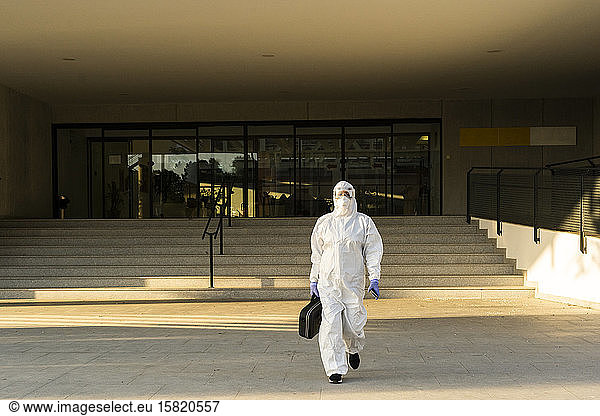 Female scientist wearing protective suit and mask