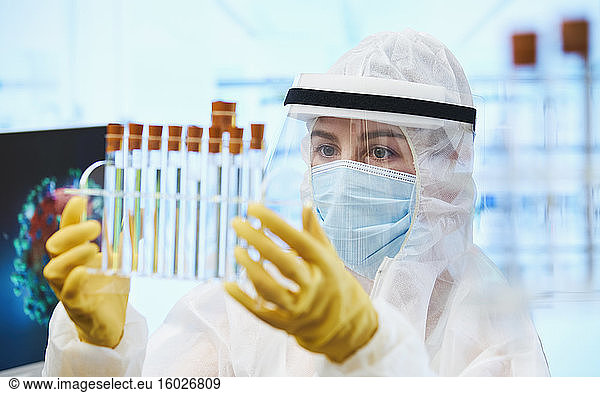 Female scientist with test tubes researching coronavirus vaccine