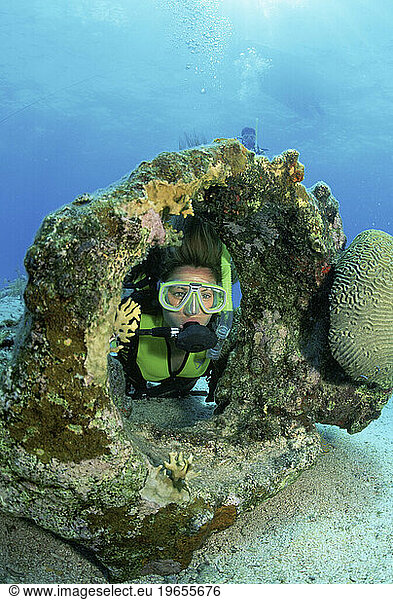 Female scuba diver amidst wreckage of a sailing vessel  Key Largo Florida