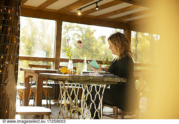 Female small business owner working at table in cafe