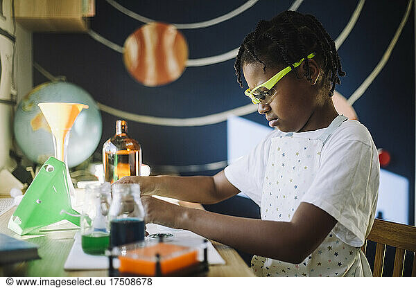 Female student concentrating while doing science project at table