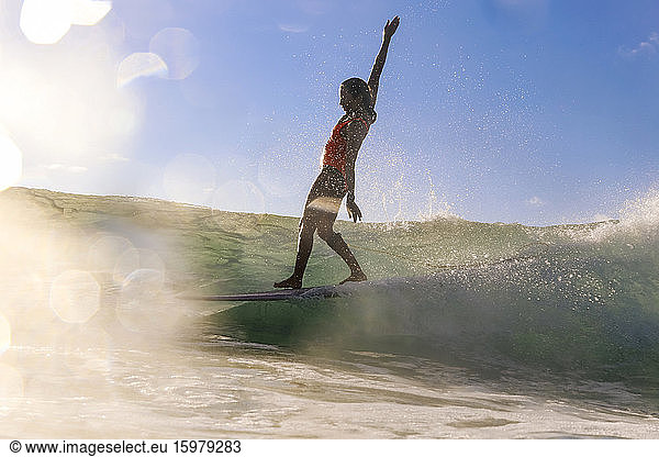 Female surfer balancing on surfboard