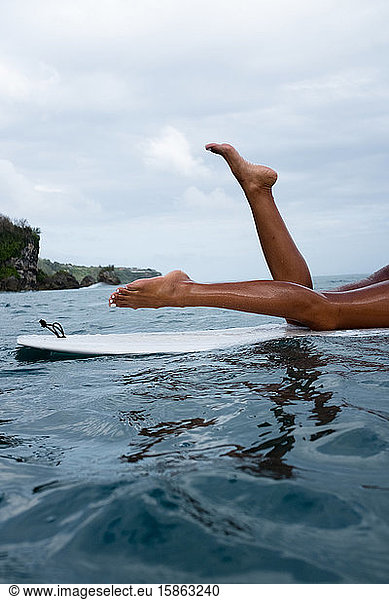 Female surfer paddles out to catch some waves