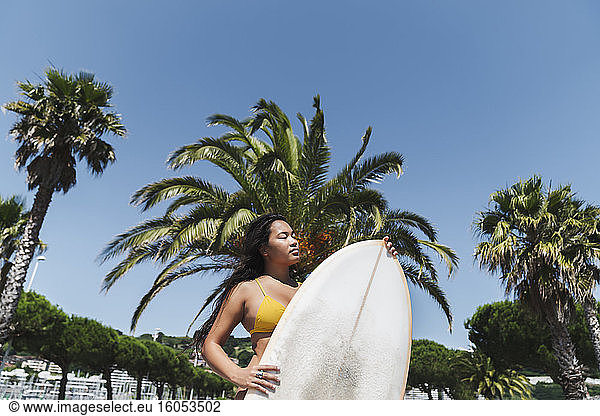 Female surfer with surfboard outdoors