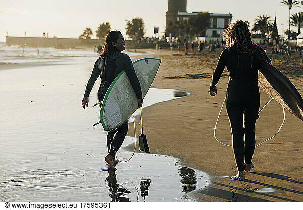 Female surfers with surfboards walking together on beach  Gran Canaria  Canary Islands