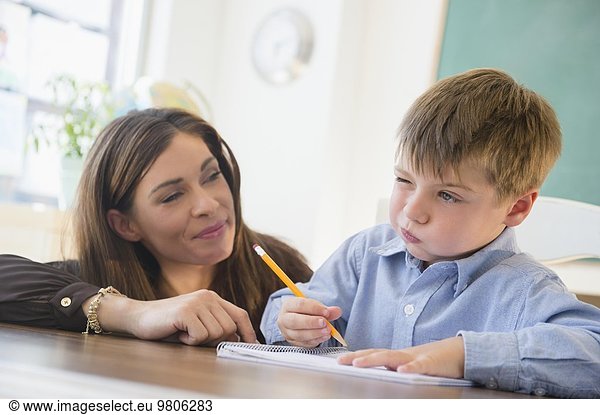 Female teacher and schoolboy (6-7) in classroom