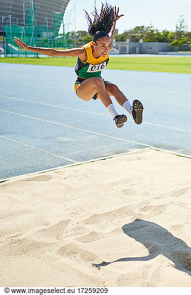 Female track and field athlete long jumping