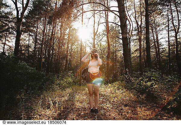 Female traveler photographing with camera in forest