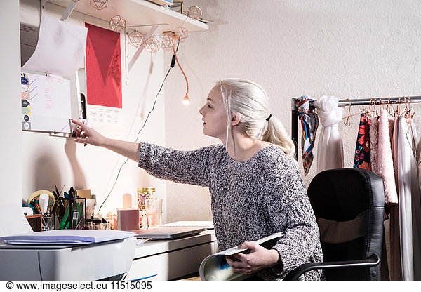 Female university student studying in the bedroom in her shared student house