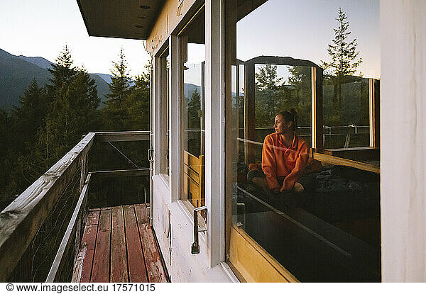 Female watching sunset from inside Heybrook fire lookout tower