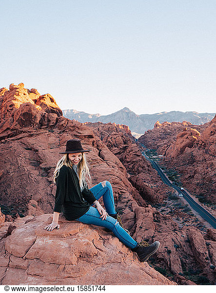 Female wearing a hat and laughing at a view point in Valley of fire