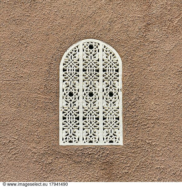 Fenster mit weißem Gitter in terrakottafarbener Wand  Ornamente  arabeskes Muster  maurischer Architekturstil  Cortijo Cabrera  Almeria  Andalusien  Südspanien  Spanien  Europa