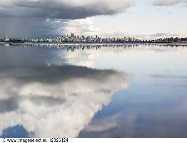 Fernsicht auf die Skyline von Vancouver über dem sich in den Wolken spiegelnden Pazifischen Ozean  gesehen von Spanish Banks; Vancouver  British Columbia  Kanada