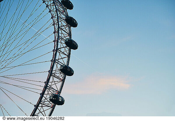 Ferris wheel against sky with contrail