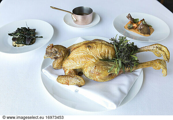 Festive whole roast chicken with head and feet  sweet potato and kale