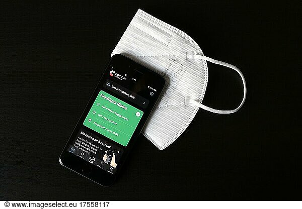 FFP2 mask and iPhone with low-risk Corona warning app  symbol smartphone apps to protect against Covid-19  Germany  Europe