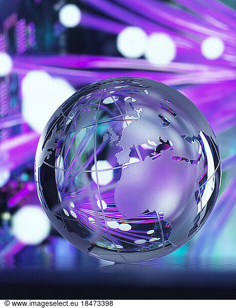 Fibre optics reflected on glass globe against colored background