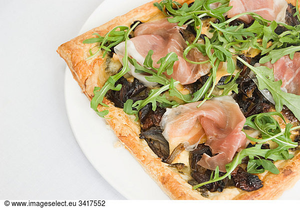 Filo pastry pizza topped with prosciutto  caramelized onion and rocket
