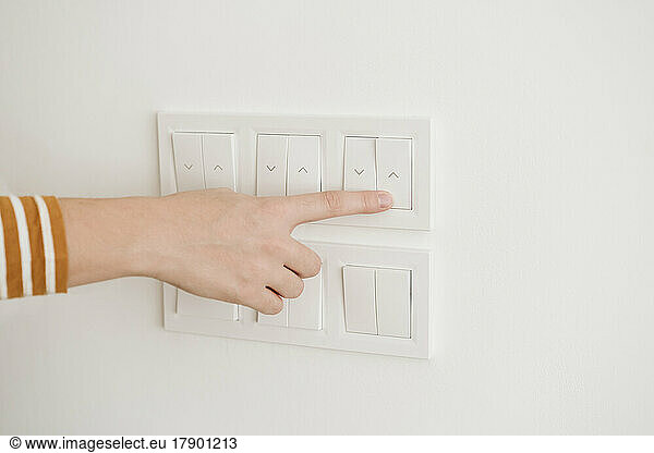 Finger touching switch for blinds on the wall