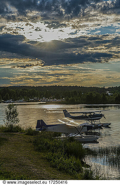 Finland  Lapland  Inari  Dramatic sunset over seaplanes left on shore of Lake Inari