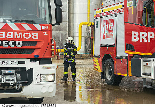 Firefighter walking thoughtfully between trucks during a training.