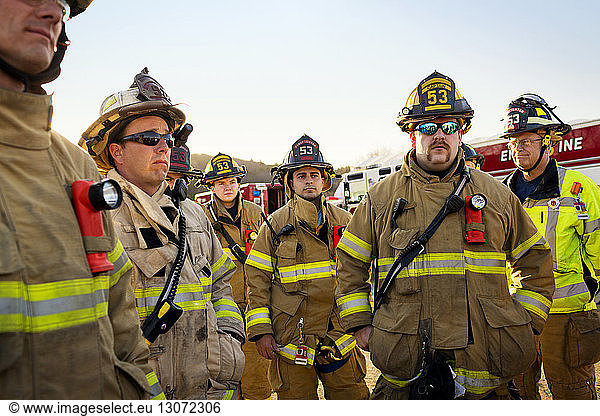 Firefighters team standing against clear sky