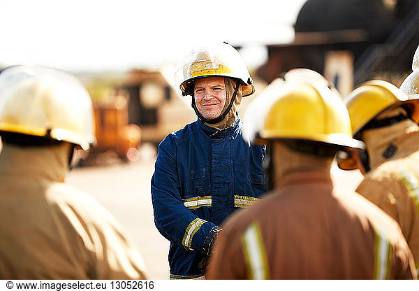 Firemen training  firemen listening to supervisor at training facility  over shoulder view