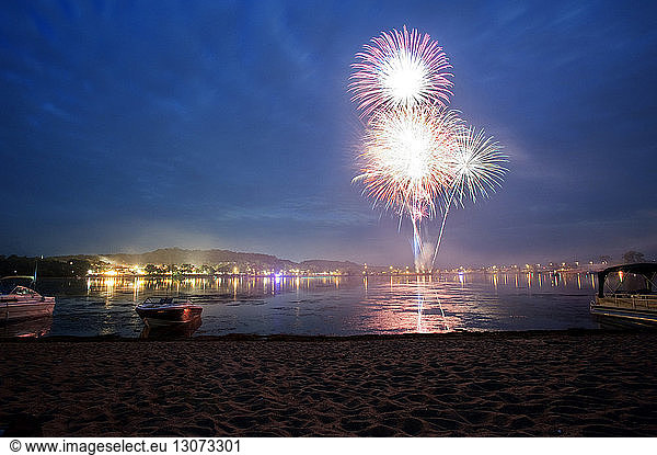 Fireworks display in sky over sea