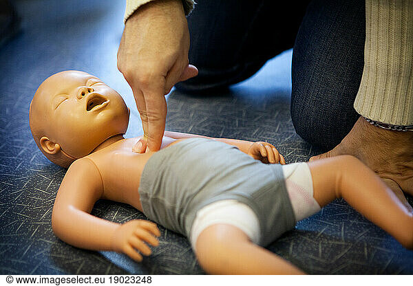 First aid training: cardiac massage on an infant.