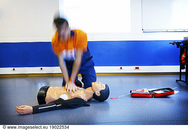 First aid training: demonstration of the use of a defibrillator on a mannequin.