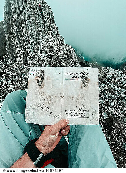 First person shot of alpine book on summit of Swiss peak