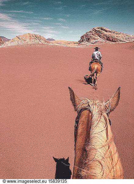 First person view of a young male horseback riding through Desert
